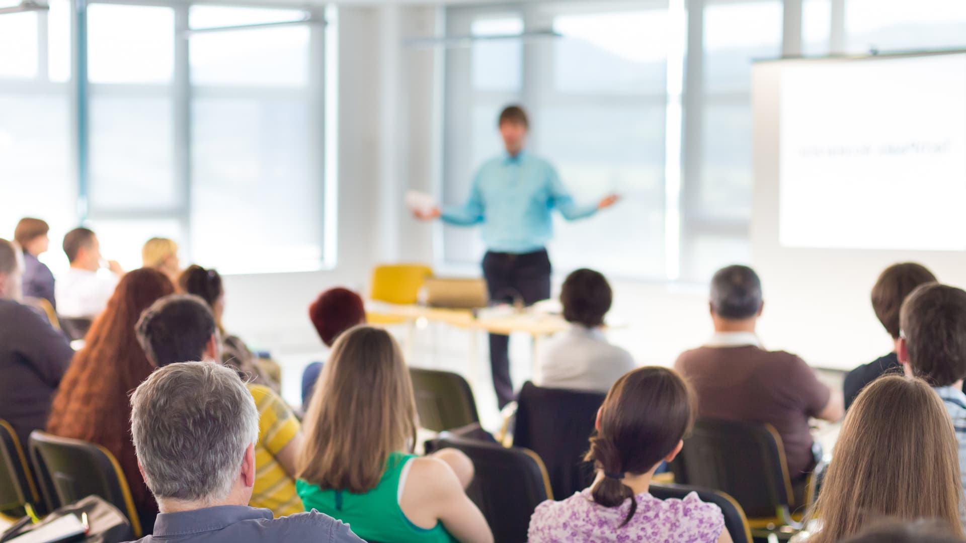 Cotemig Wallpaper Um professor dando aula para vários alunos sentados nas suas cadeiras
